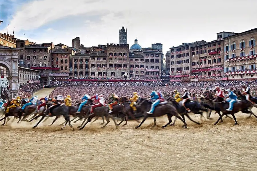 Jockeys racing their horses in the traditional Palio di Siena, one of Italy’s most vibrant cultural events.