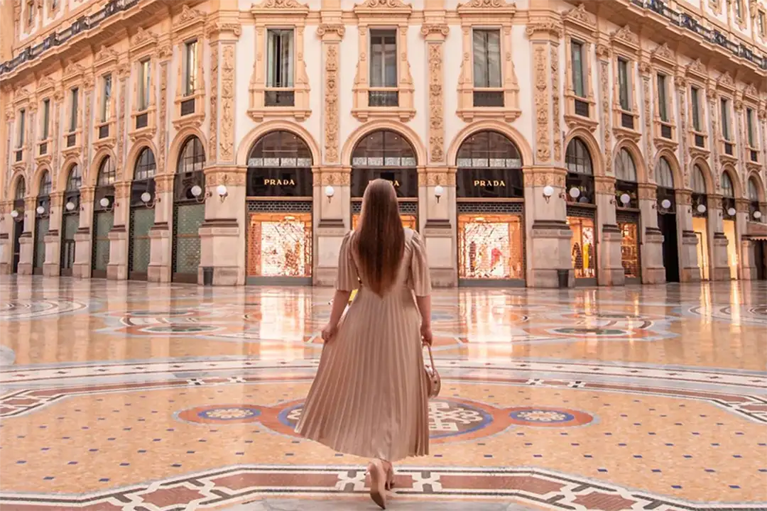 Elegant woman walking through Galleria Vittorio Emanuele II in Milan, a landmark of sophistication and Italian fashion.
