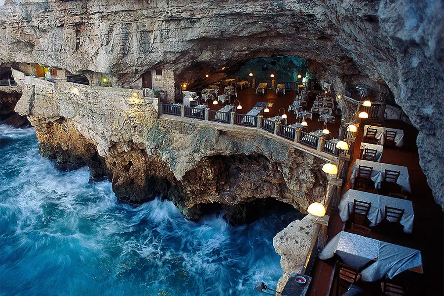 Grotta Palazzese restaurant in Polignano a Mare, with tables set inside a cave above the Adriatic Sea, creating a unique and stunning atmosphere